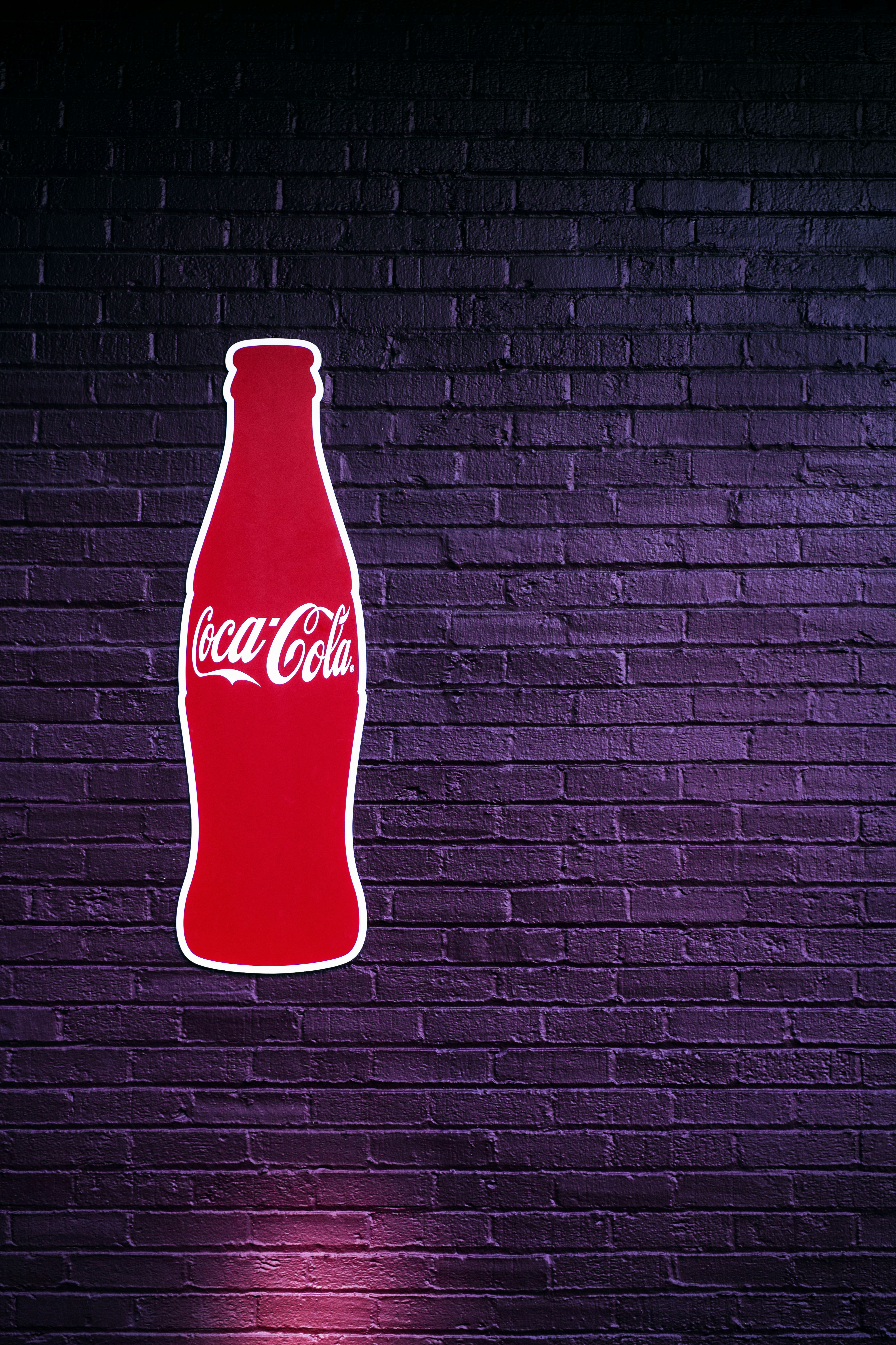 red coca cola bottle on black and white striped wall